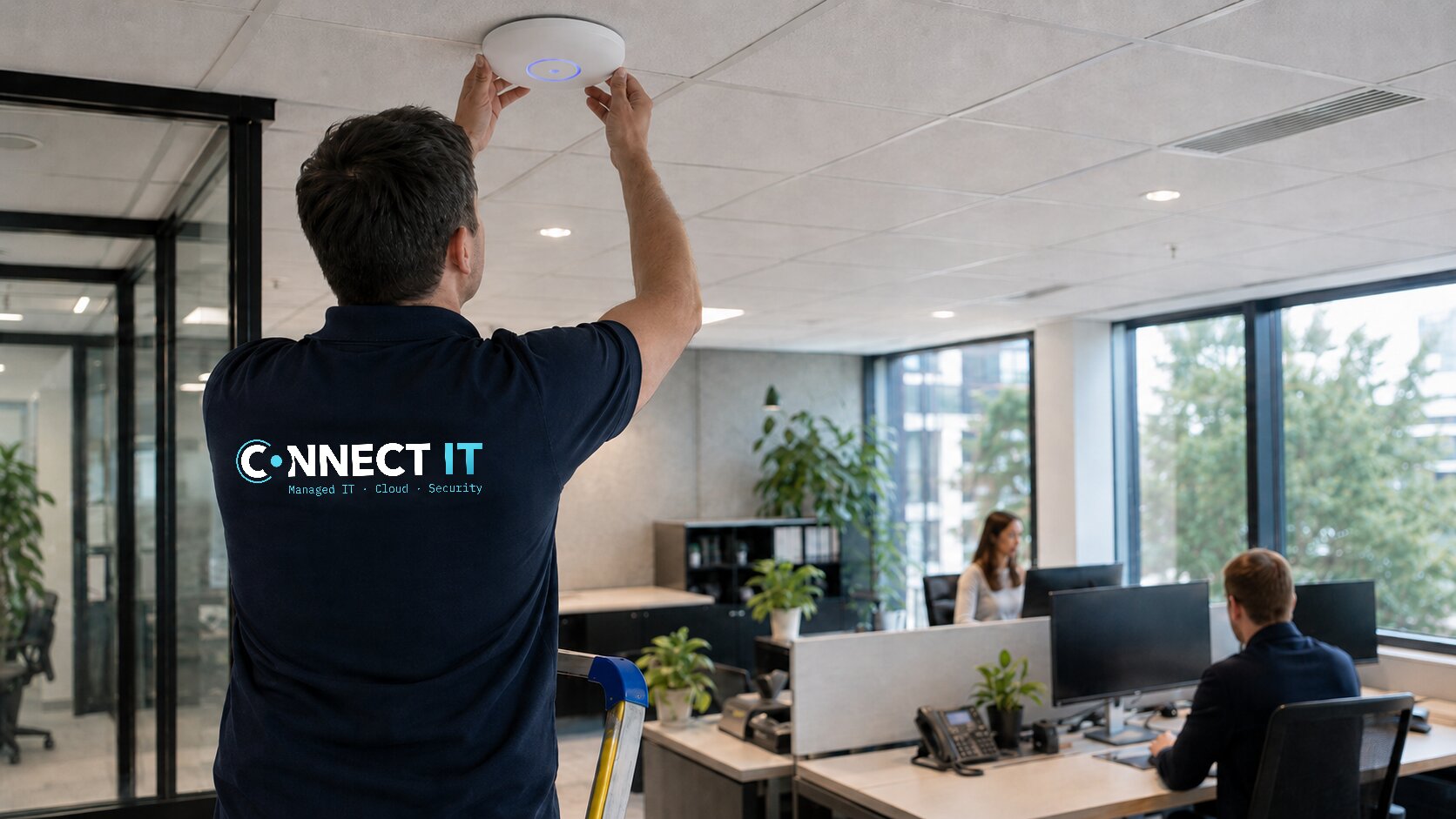 Connect IT-engineer installeert een wifi-accesspoint aan het plafond van een kantoor